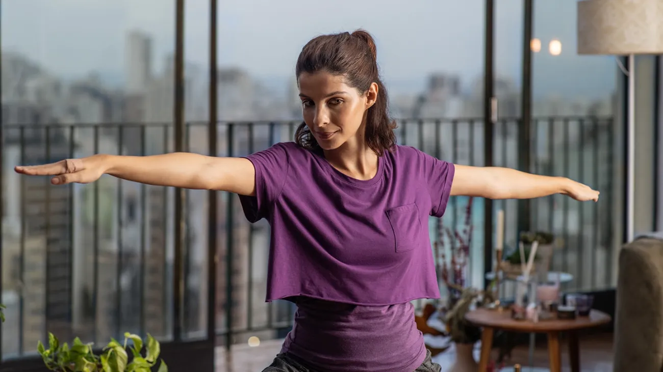 A woman in her home practicing yoga.