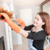 Woman cleaning the living room with a duster