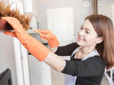 A woman dusting her home