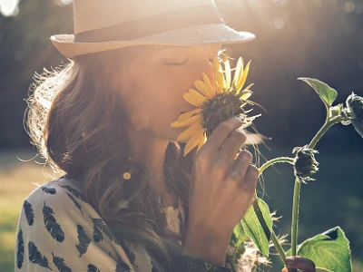 Femme sentant une fleur sur une journée ensoleillée