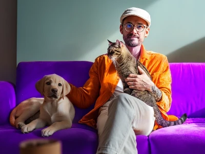 Jovem segurando um gato nos braços em ambiente fechado.