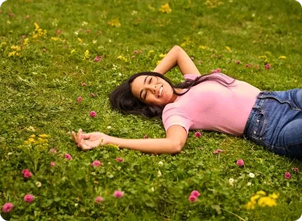 Eine Familie sitzt zusammen im Gras und bläst Seifenblasen.