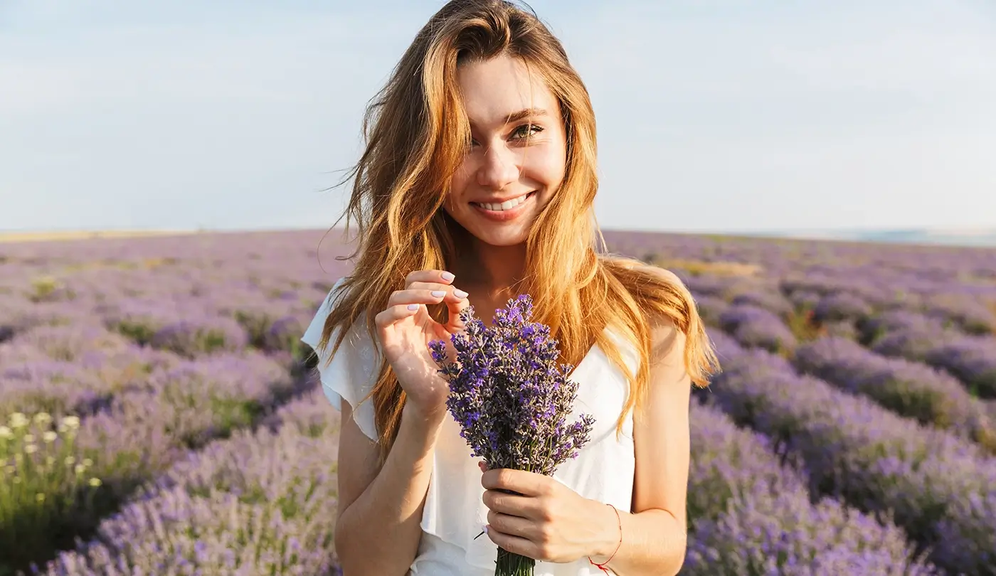 A woman stands in a field of lavender.
