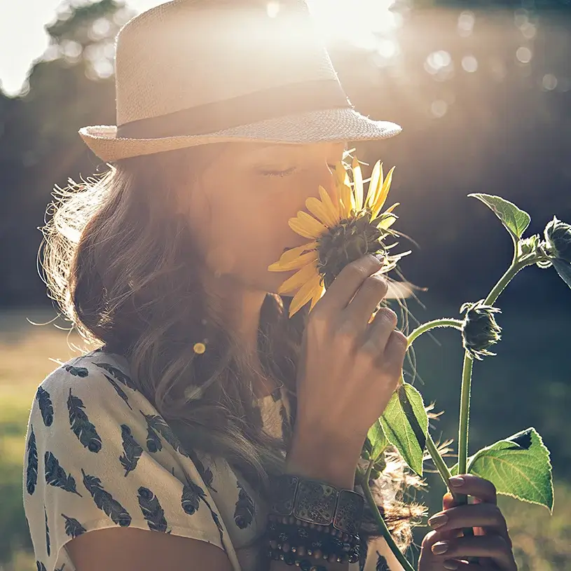 Woman smelling flower on a sunny day