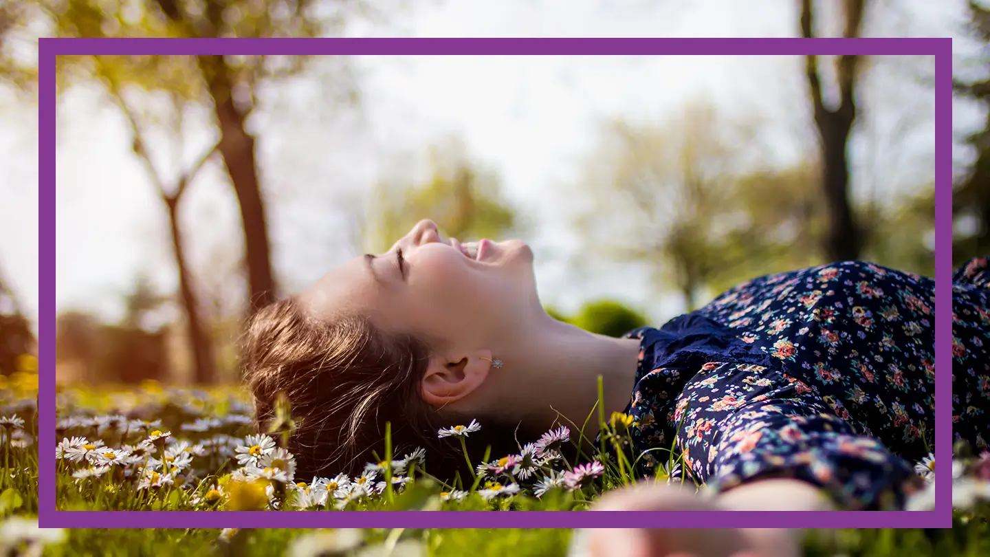 Uśmiechająca się kobieta, leżąca na łące