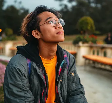 Um jovem sorrindo enquanto está na frente de uma van.